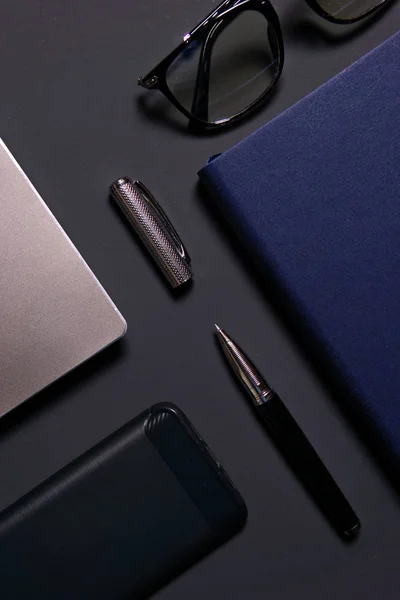 Dizüstü bilgisayar, dizüstü bilgisayar, gözlükler ve kalem masada. İş veya çalışma kavramı.