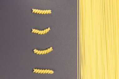 Gri arka planda spiral şeklinde ham İtalyan makarna