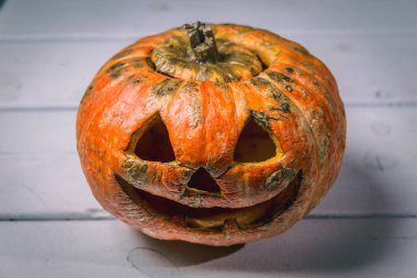 Beyaz tahtaların bir arka plan üzerinde ahşap bir masa üzerinde Halloween kabak. Cadılar Bayramı arka plan.