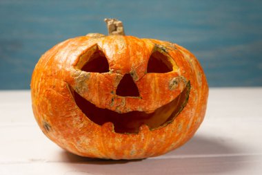 Beyaz tahtaların bir arka plan üzerinde ahşap bir masa üzerinde Halloween kabak. Cadılar Bayramı arka plan.
