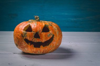 Beyaz tahtaların bir arka plan üzerinde ahşap bir masa üzerinde Halloween kabak. Cadılar Bayramı arka plan.