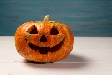 Beyaz tahtaların bir arka plan üzerinde ahşap bir masa üzerinde Halloween kabak. Cadılar Bayramı arka plan.