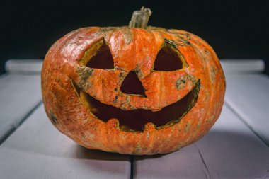 Beyaz tahtaların bir arka plan üzerinde ahşap bir masa üzerinde Halloween kabak. Cadılar Bayramı arka plan.