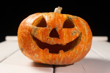 Beyaz tahtaların bir arka plan üzerinde ahşap bir masa üzerinde Halloween kabak. Cadılar Bayramı arka plan.