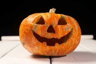 Beyaz tahtaların bir arka plan üzerinde ahşap bir masa üzerinde Halloween kabak. Cadılar Bayramı arka plan.