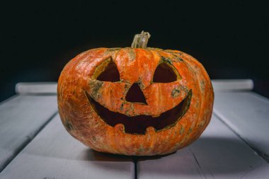 Beyaz tahtaların bir arka plan üzerinde ahşap bir masa üzerinde Halloween kabak. Cadılar Bayramı arka plan.