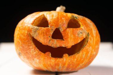 Beyaz tahtaların bir arka plan üzerinde ahşap bir masa üzerinde Halloween kabak. Cadılar Bayramı arka plan.