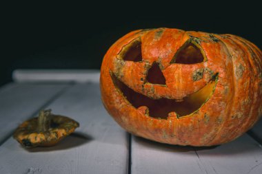 Beyaz tahtaların bir arka plan üzerinde ahşap bir masa üzerinde Halloween kabak. Cadılar Bayramı arka plan.