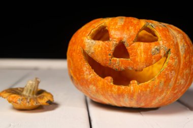 Beyaz tahtaların bir arka plan üzerinde ahşap bir masa üzerinde Halloween kabak. Cadılar Bayramı arka plan.