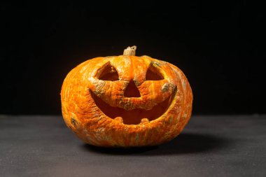 karanlık bir arka plan üzerinde gülümseyen Halloween kabak