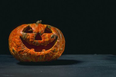 karanlık bir arka plan üzerinde gülümseyen Halloween kabak