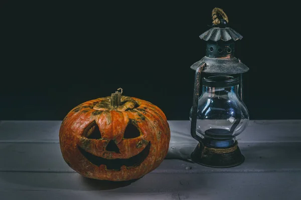 Halloween pumpkin and lamp. Happy Halloween holiday background with old vintage lamp.