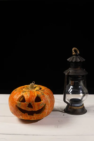 Halloween pumpkin and lamp. Happy Halloween holiday background with old vintage lamp.