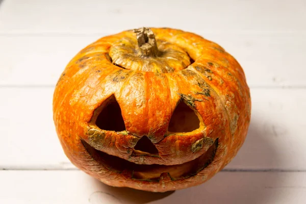Beyaz tahtaların bir arka plan üzerinde ahşap bir masa üzerinde Halloween kabak. Cadılar Bayramı arka plan.