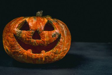 karanlık bir arka plan üzerinde gülümseyen Halloween kabak
