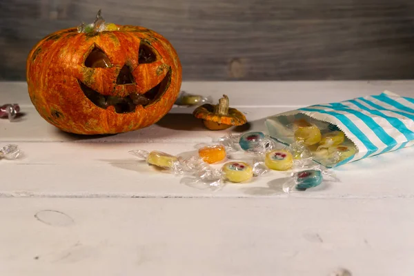 Beyaz bir masada Cadılar Bayramı balkabağı ve şekerler