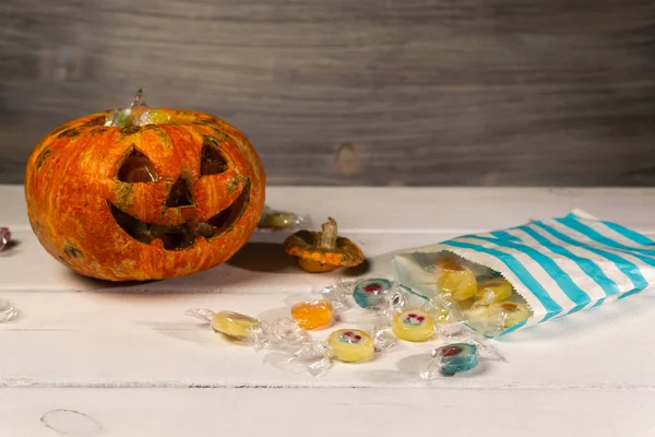 Beyaz bir masada Cadılar Bayramı balkabağı ve şekerler