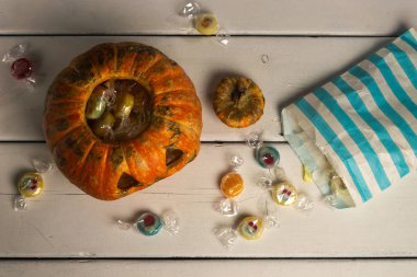 Beyaz bir masada Cadılar Bayramı balkabağı ve şekerler