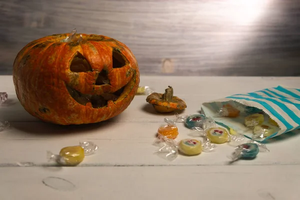 Beyaz bir masada Cadılar Bayramı balkabağı ve şekerler