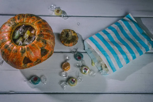 Beyaz bir masada Cadılar Bayramı balkabağı ve şekerler