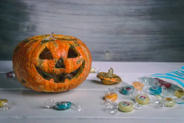 Beyaz bir masada Cadılar Bayramı balkabağı ve şekerler