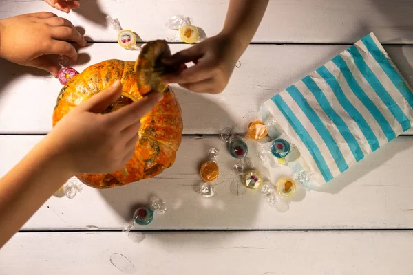 Cadılar Bayramı masası. Çocuğun elleri. cadılar bayramı kabak ve şekerler.