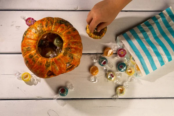 Cadılar Bayramı masası. Çocuğun elleri. cadılar bayramı kabak ve şekerler.