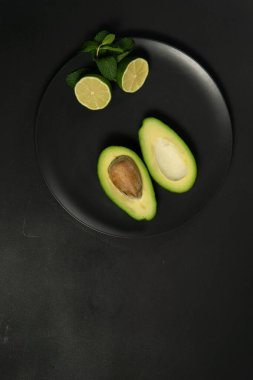 Koyu arkaplanda limonlu avokado
