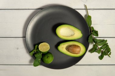 Beyaz ahşap arka planda limonlu avokado