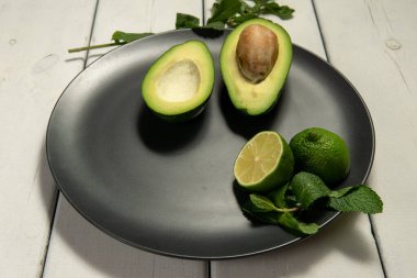 Beyaz ahşap arka planda limonlu avokado