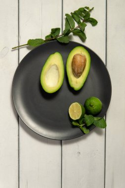 Beyaz ahşap arka planda limonlu avokado