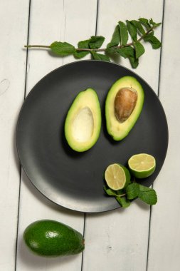 Beyaz ahşap arka planda limonlu avokado