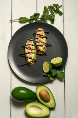 Beyaz ahşap arka planda karides, avokado ve limonlu bruschetta.