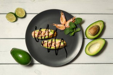 Beyaz ahşap arka planda karides, avokado ve limonlu bruschetta.