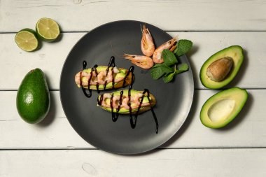 Beyaz ahşap arka planda karides, avokado ve limonlu bruschetta.