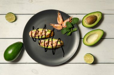 Beyaz ahşap arka planda karides, avokado ve limonlu bruschetta.