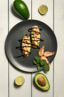 Beyaz ahşap arka planda karides, avokado ve limonlu bruschetta.