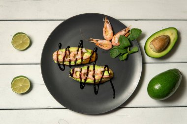 Beyaz ahşap arka planda karides, avokado ve limonlu bruschetta.