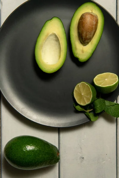 Avokado med lime på en vit trä backgroung — Stockfoto