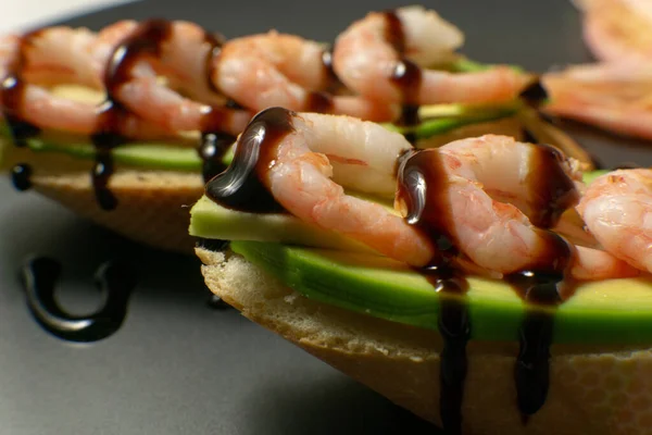 Bir tabakta karides, avokado ve limonlu bruschetta.