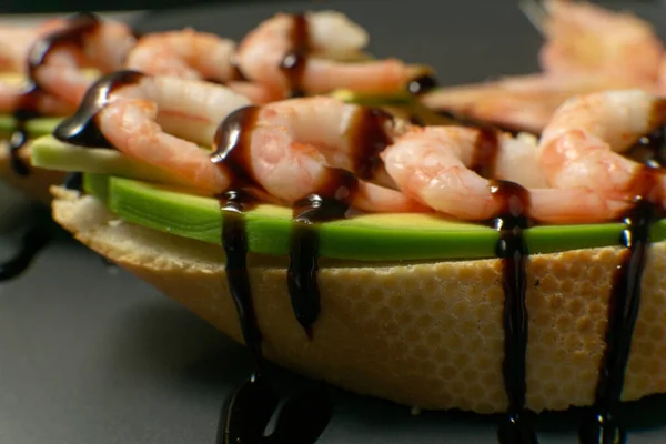 Bir tabakta karides, avokado ve limonlu bruschetta.