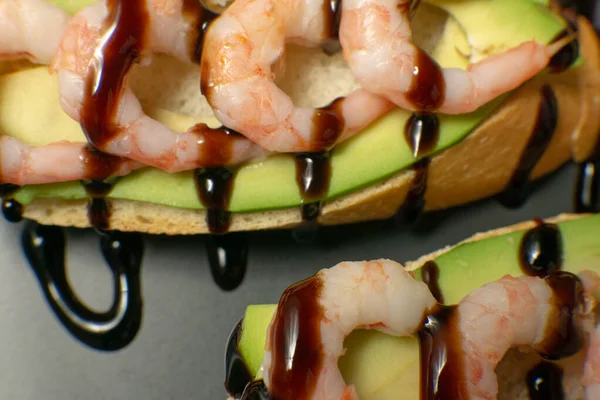 Bir tabakta karides, avokado ve limonlu bruschetta.