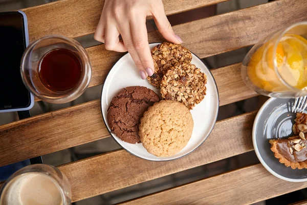 sweet dessert with a cup of coffee and female hands with a phone