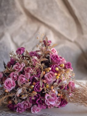 Kumaş ve taş arka plan üzerinde Vintage yapay gül çiçek buketi