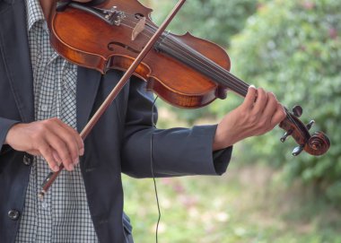 Park arka planda keman ile bir şarkı çalmaya müzisyen elleri