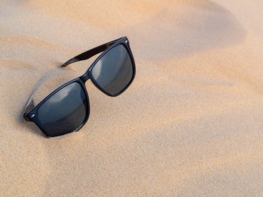 Güneş gözlüğü kum plaj, yansıma deniz ve gökyüzü yaz gündoğumu ile
