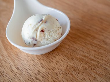 Ev yapımı Rum Raisin dondurma ahşap arka plan üzerinde küçük beyaz Kupası kepçe
