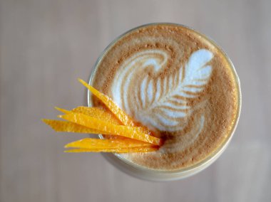 Düz yatıyordu yakın çekim Cappuccino Romano kahve limon ya da portakal Topping dilim cam ahşap masa arka plan üzerinde
