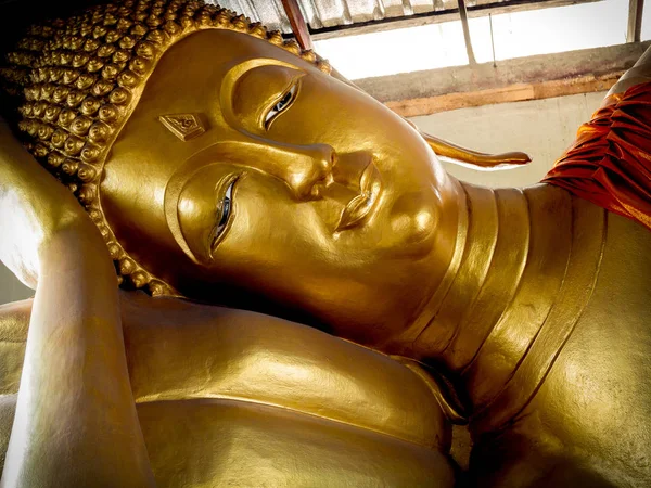 斜倚的金色佛像雕像 泰国地方寺庙屋顶下的特写美丽的睡佛脸 — 图库照片