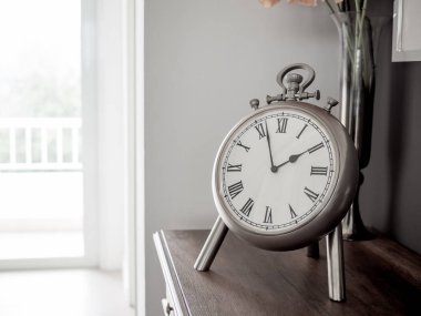 Paslanmaz Klasik Vintage Romen Rakamlari saat. Natürmort beyaz odada ahşap dolap üzerinde.